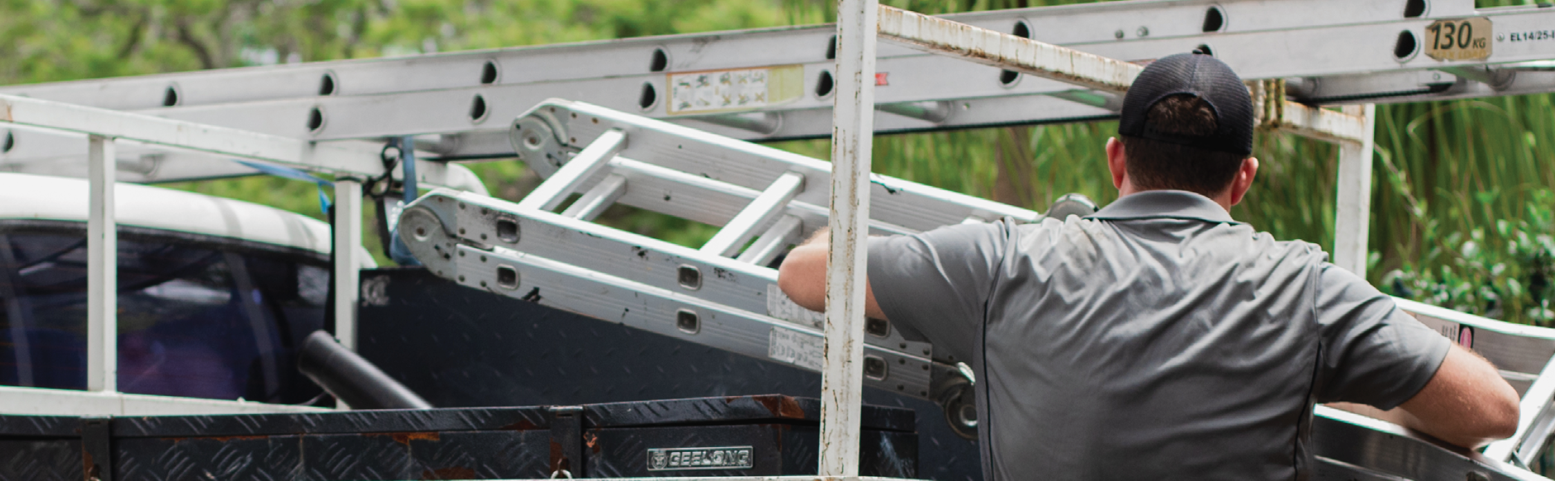 picture of man loading a truck with ladder and white writings "carry the essentials"