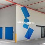 A storage facility with blue doors and a sign that says life sorted.
