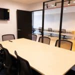 A conference room with a large table and chairs.