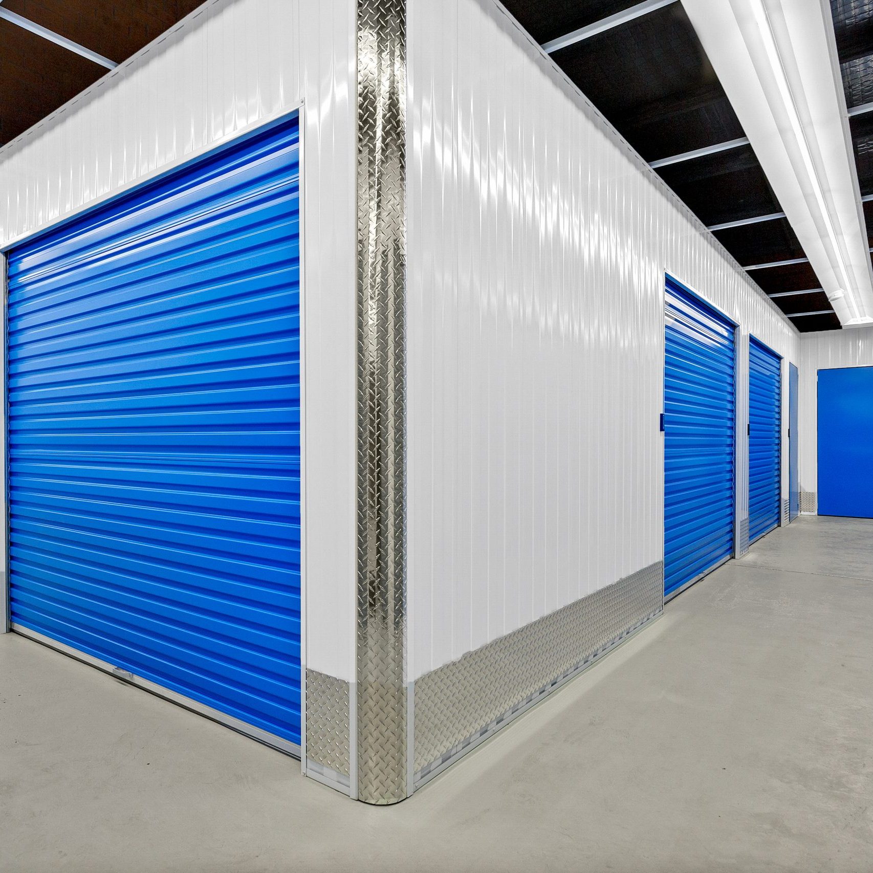 A storage unit with blue doors and white walls.