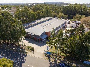 An aerial view of a warehouse in the middle of a forest.