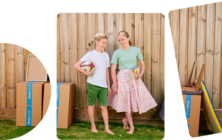 Two children standing in front of a wooden fence with boxes in front of them.