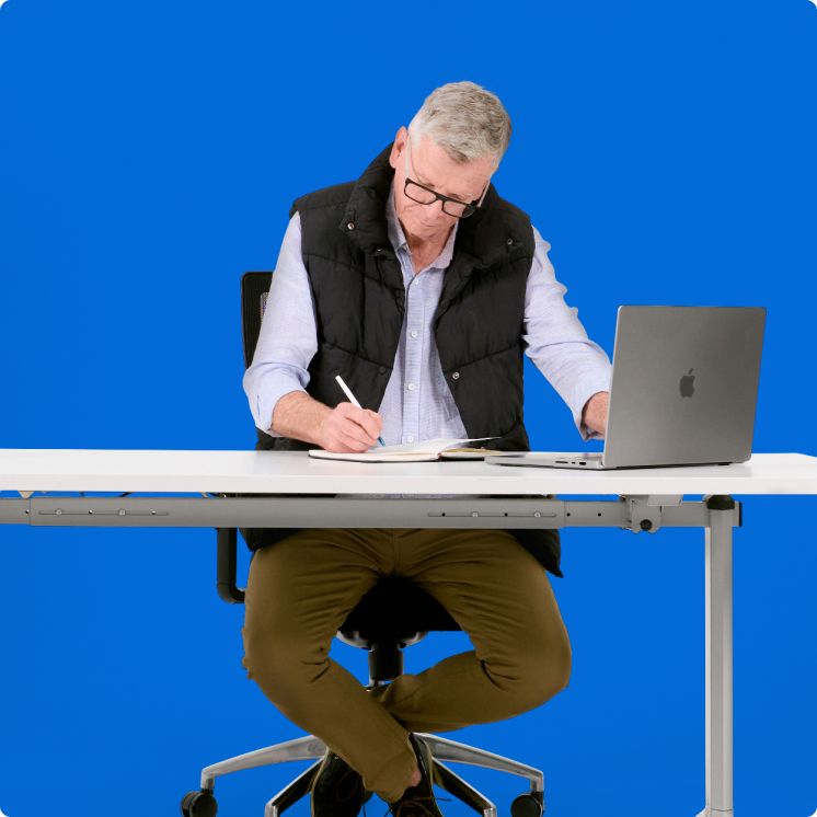 A man sitting at a desk with a laptop.