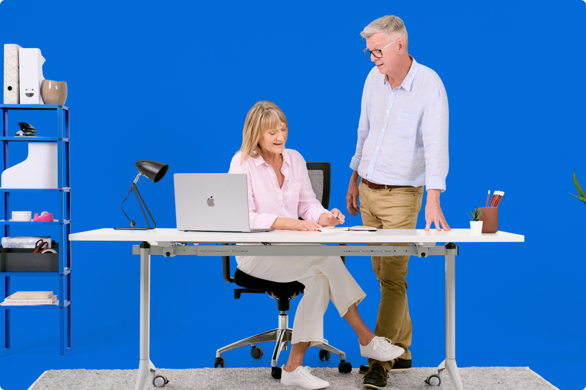 A man and woman standing at a desk.