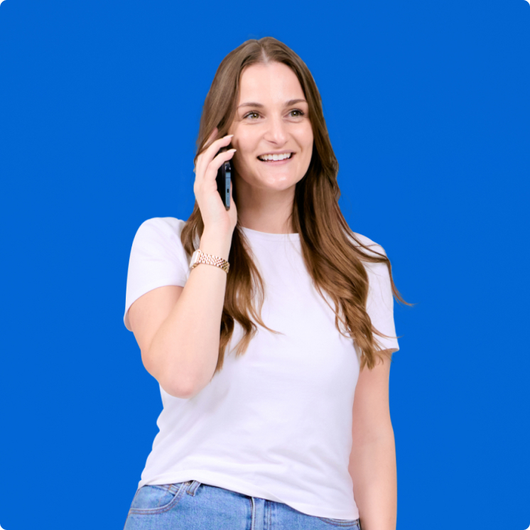 A woman talking on a cell phone against a blue background.